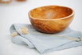 Image of a wooden bowl, standing on a napkin on a white surface