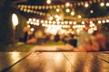 Image of wooden table in front of abstract blurred restaurant lights background Royalty Free Stock Photo