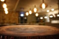 Image of wooden table in front of abstract blurred restaurant lights background Royalty Free Stock Photo