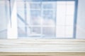 image of wooden table in front of abstract blurred window light background.