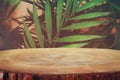 image of wooden table in front tropical green floral background. for product display and presentation Royalty Free Stock Photo