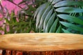 image of wooden table in front tropical green floral background. for product display and presentation Royalty Free Stock Photo