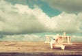 Image of wooden toy airplane over wooden table against cloudy sky. retro style image Royalty Free Stock Photo