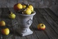 Image of wrinkled apples in an old vase on a shabby wooden table