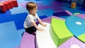 Image of 3 years old toddler boy climbing and crawling on the children palyground in shopping mall. There are lots of Royalty Free Stock Photo