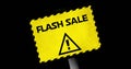 Image of yellow board with flash sale text and alertness sign over black background