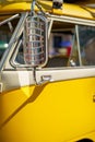 Image of a yellow tour bus with chrome rear view mirror