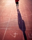 Image of young adult male athlete from behind started run at athletic track. Conceptual, artistic image