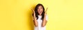 Image of young african american woman looking annoyed, screaming bothered and angry, standing over yellow background