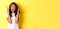 Image of young african american woman looking annoyed, screaming bothered and angry, standing over yellow background