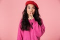 Image of young asian girl wearing beret holding index finger on lips Royalty Free Stock Photo