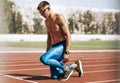 Image of young athlete man preparing for running on racetrack at stadium. Sportsman, male runner sprinting during training session Royalty Free Stock Photo