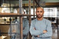 Image of bald african american man standing with arms crossed in office Royalty Free Stock Photo