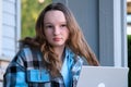 Image of a young beautiful joyful woman smiling while working with a laptop outdoors on the porch beautiful young teen Royalty Free Stock Photo