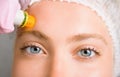 Image of a young beautiful woman dressed as a patient, lying on a couch in a cosmetology clinic.