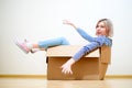 Image of young blond woman sitting in cardboard box Royalty Free Stock Photo
