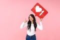 Image of young brunette asian woman holding heart like symbol on placard