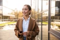 Image of young brunette asian woman using mobile phone on city street Royalty Free Stock Photo