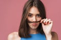 Image of young brunette woman having fun and putting her hair as mustache Royalty Free Stock Photo