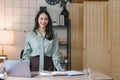 Image of a young, cheerful, happy, positive, cute, and beautiful Asian millennial businesswoman standing indoors in a Royalty Free Stock Photo