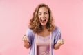 Image of young delighted woman screaming and making winner gesture