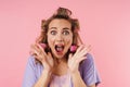 Image of young frightened woman in curler screaming at camera