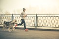 Image of young girl running with her dog, alaskan malamute Royalty Free Stock Photo