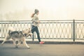 Image of young girl running with her dog, alaskan malamute Royalty Free Stock Photo