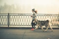 Image of young girl running with her dog, alaskan malamute Royalty Free Stock Photo