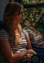 Young girl in sunset lighting traveling in train car and her reflection in window Royalty Free Stock Photo