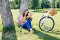 Image of young happy woman sitting under tree with book Royalty Free Stock Photo