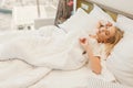 Image of young lady lying in bed in hotel room Royalty Free Stock Photo