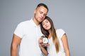 Portrait of young loving couple holding alarm clock sleeping isolated on gray background Royalty Free Stock Photo