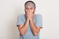 Image of young man with beard wearing casual gray t shirt over white isolated background, unshaven man yawning, looks tired, Royalty Free Stock Photo