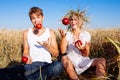 Image of young man and woman with apples on wheat field Royalty Free Stock Photo