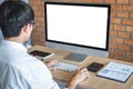 Image of Young man working in front of the computer laptop looking at screen with a clean white screen and blank space for text Royalty Free Stock Photo