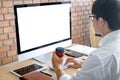 Image of Young man working in front of the computer laptop looking at screen with a clean white screen and blank space for text Royalty Free Stock Photo