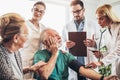 Young medic taking blood pressure during home visit Royalty Free Stock Photo