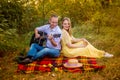 Young man playing guitar for a girl in the park