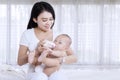 Young mother giving milk to her baby at home Royalty Free Stock Photo