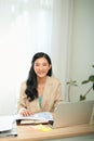 Image of young pleased happy cheerful cute beautiful business woman sit indoors in office using laptop computer Royalty Free Stock Photo