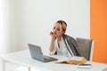 Image of young pleased happy cheerful cute beautiful business woman sit indoors in office using laptop computer Royalty Free Stock Photo