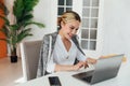 Image of young pleased happy cheerful cute beautiful business woman sit indoors in office using laptop computer Royalty Free Stock Photo