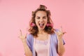 Image of young sassy woman screaming and making horns gesture Royalty Free Stock Photo