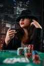 image of a young sexy woman playing poker with a cigarette and smoke coming out of it. poker in the casino Royalty Free Stock Photo