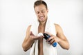 Image of young smiling man with white towel on his shoulders holding shaving foam in his hand doing his morning routine