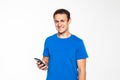 Young man in sportswear posing and using cellphone isolated over gray background Royalty Free Stock Photo