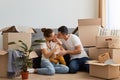 Image of young wife and husband posing in their new house on moving day, family with infant daughter relocating in a new apartment Royalty Free Stock Photo