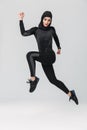 Woman fitness muslim posing running jumping isolated over white wall background Royalty Free Stock Photo