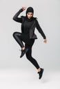 Fitness muslim woman posing running jumping  over white wall background Royalty Free Stock Photo